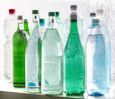 Different varieties of mineral water in bottles made of glass and plastic or PET