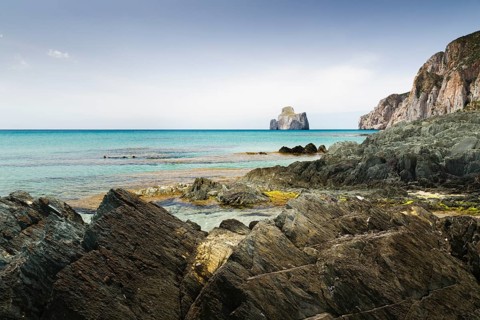 Spiaggia di Masua bay with the Pan di Zuccherof ??rock island in the sea