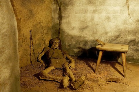Rats and the remains of a starved prisoner in the dungeon