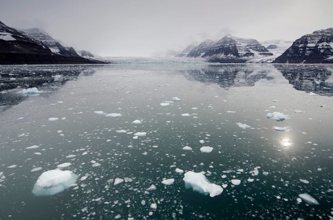 Icebergs in front of cloud veiled mountain and glacier scenery