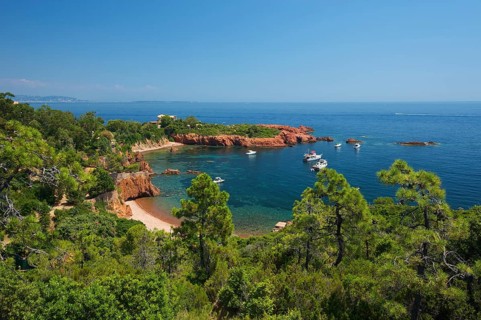 Calanque bay with boats at Cap Roux in the Esterel mountains