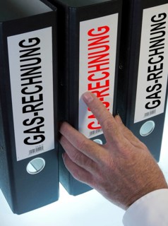 Hand reaching for a ring binder labeled Gasrechnung