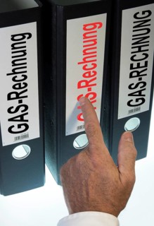 Hand pointing to a ring binder labeled Gasrechnung