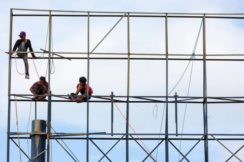 Unsecured workers assembling a scaffold
