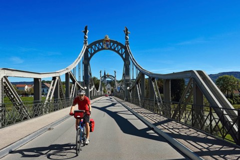 Cyclist crossing Laenderbruecke bridge between Bavaria and Salzburger Land