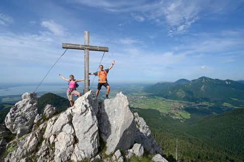 Hikers standing next to the cross on the summit of Friedenrath mountain