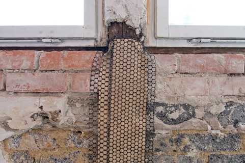 Metal mesh or lath with insulating paper for a supportive plaster base