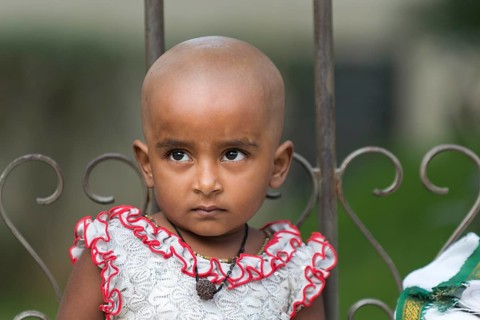 Girl with a shaved head after making a sacrificial offering
