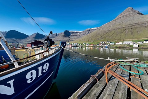 Fishing boat and rusty anchors in the harbour of Hvannasund