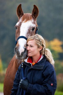 Young woman cuddling a Austrian Warmblood