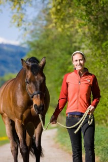 Young woman leading an Austrian Warmblood