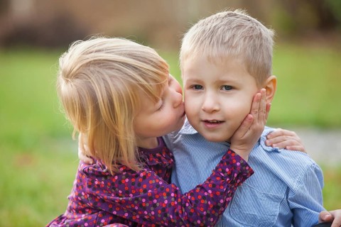Little girl kissing a little boy