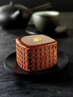 Cake with a sponge case and chocolate filling in a black Japanese tea setting