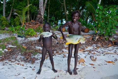Boys proudly showing the fish they caught