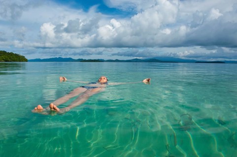 Tourist floating in the clear water of the Marovo Lagoon