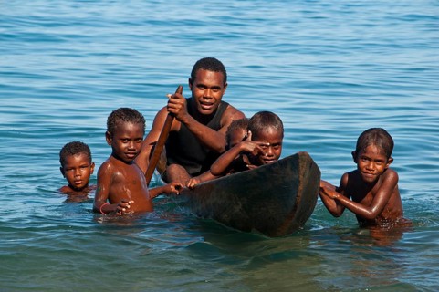 A man and children with a canoe
