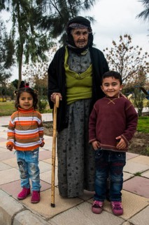 Syrian Orthodox Kurdish woman with tattoos on her face and her grandchildren