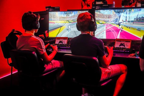 Boys playing computer games in front of screens
