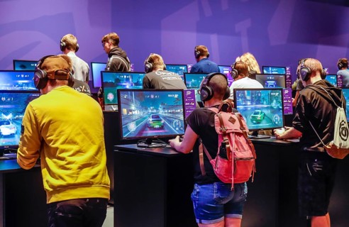 Young visitors at Need for Speed car racing game in front of screens