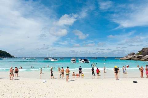 Tourists and boats on the white sandy beach of Ao Kueak