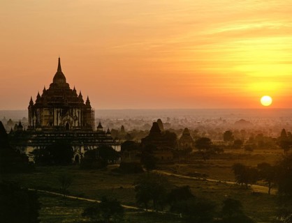 Field with ruins of Buddhist pagodas with Thatbyinnyu Temple at sunset
