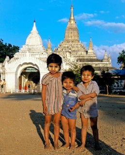 Children with Thanaka paste on their faces in front of Buddhist pagodas