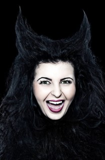 Laughing young woman dressed as a devil with horns
