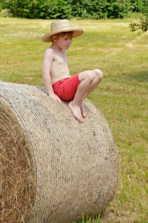 Boy sitting on a bale of straw