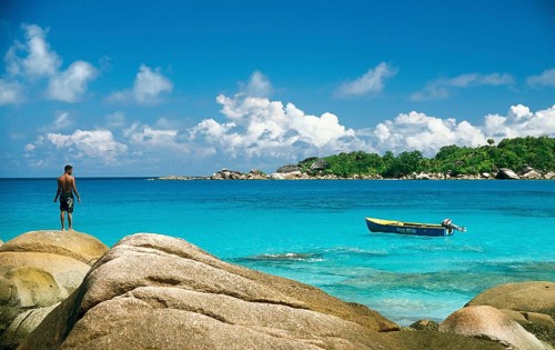 Rocky beach with a local fisherman and a fishing boat