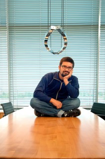 Young man sitting cross-legged on a conference desk