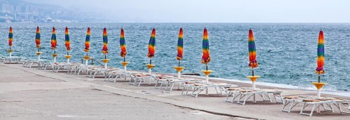 Umbrellas and deckchairs during the preseason on the beach of Opatija on the Mediterranean Sea in Kvarner Bay