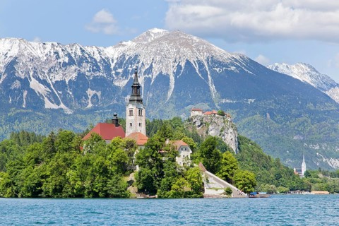 Blejski Otok Island with St. Mary's Church in Lake Bled and The Karawanks mountain range in Bled
