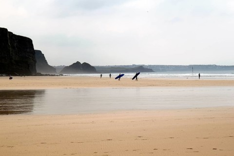 Surfers on the beach at low tide