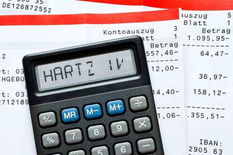 Calculator with the term "Hartz IV" in the display and bank statements