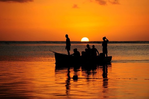 Fishermen on a boat at sunset