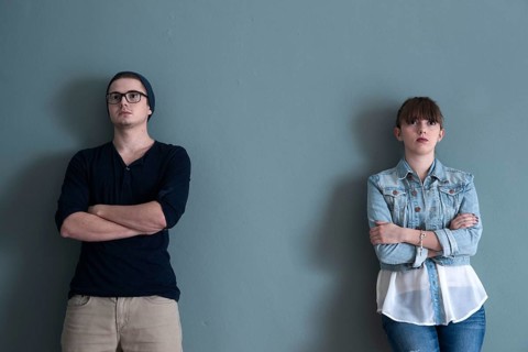 Young couple leaning on a wall