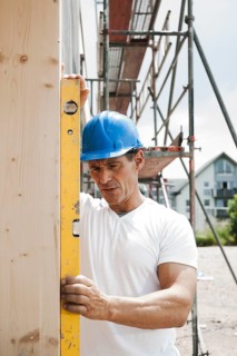 Construction manager controlling the window installation with a spirit level