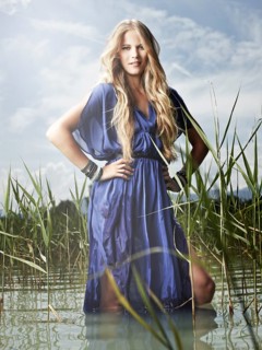 Woman wearing a blue dress standing between the reeds