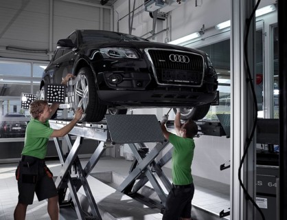 Workers assembling panels to track wheel alignments