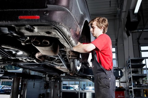 Car mechanic changing tyres in a car repair shop