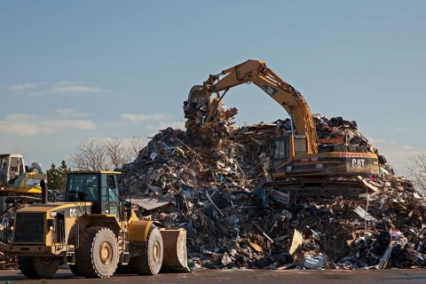 Workers pile debris from Hurricane Sandy in a parking lot next to the beach on Staten Island