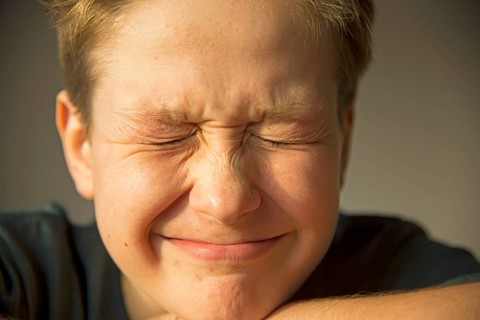 Twelve year old boy squinting his eyes