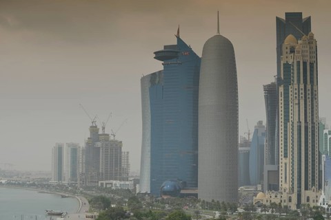 Smog over Corniche waterfront promenade with the skyline of Doha with Al Bidda Tower