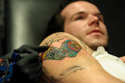 A young man is getting a tattoo