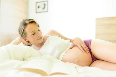 Pregnant woman lying in bed