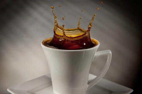 Sugar cube falling into a cup of coffee
