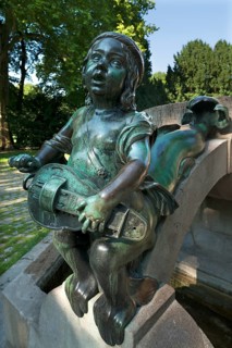 Child's sculpture with musical instrument and fish fin on Minnesangerbrunnen fountain