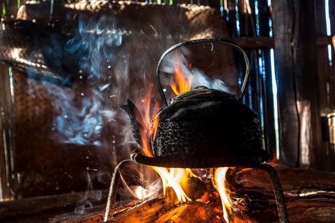Kettle over an open fire in a kitchen made of bamboo