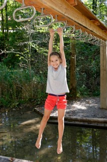 Girl swinging above water