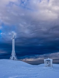 Summit cross and a small hut covered with hoarfrost